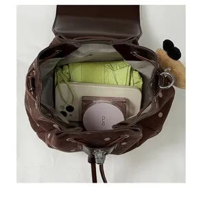Top view inside a brown dotted suede bag, with drawstring closure and everyday items