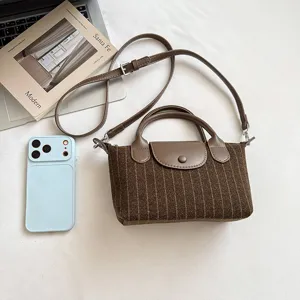 Vue à plat d'un sac à fines rayures brunes, avec anses, rabat à pression et bandoulière réglable
