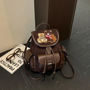 Brown faux suede backpack with faux leather panels, teddy bear embroidery and flap closure