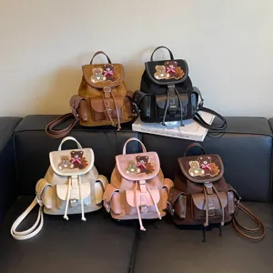 Five vintage faux suede backpacks with teddy bear patches, flap closures and drawstring tops