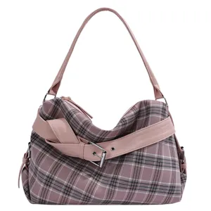 Pink plaid bag with faux-leather trim, a silver buckle, and a single shoulder strap on white