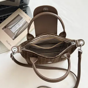 Vue plongeante sur un sac à carreaux ouvert, avec doublure rayée et poche intérieure zippée.