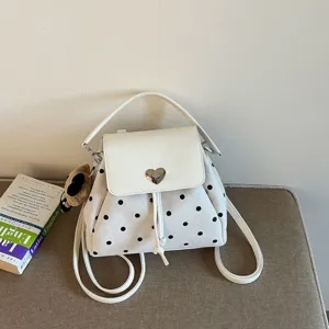 White faux-suede polka-dot convertible backpack with a heart clasp and brown bear charm