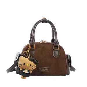 Sac brun foncé effet daim vu de face, avec poignées, détails métalliques et pendentif en peluche
