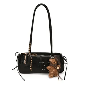Dettaglio di una borsa nera con borchie a stella, foulard leopardato e ciondolo a orsetto
