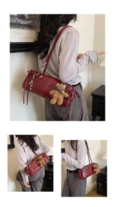 Modella con borsa a cuscino bordeaux, charm a forma di orsetto e foulard a quadri
