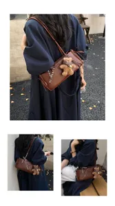 Scatti di strada mostrano una borsa a tracolla marrone strutturata con un piccolo orsetto pendente.