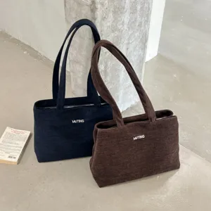 Bolsos tote texturizados en azul marino y marrón, con asas dobles y cierre de cremallera.