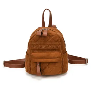 Detailansicht aus braunem Kunstvelours mit Rautensteppung, Stickerei und Besätzen aus Leder.