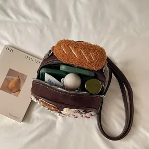 Open brown shoulder bag with a plush bread-shaped flap, zipper and visible items inside