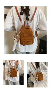 Detail eines braunen Mini-Rucksacks mit Rautensteppung, Prägung, Lederriemen und Bärenanhänger