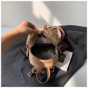 Nahaufnahme eines geöffneten braunen Rucksacks mit schwarz-weiß gestreiftem Innenfutter