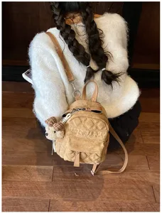 Kleiner Rucksack in sandfarbenem Velourslook mit Rautensteppung, braunen Riemen und Bärenanhänger