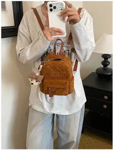 Spiegelselfie mit braunem Veloursrucksack, Rautensteppung, Bärenanhänger und Karoschleife