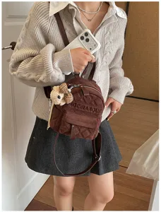 Braune gesteppte Tasche quer getragen, mit kleinem Teddyanhänger und Reißverschlussfach im Alltag.
