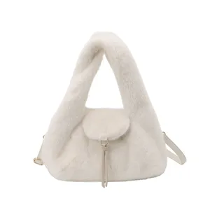 Studio view of a white faux-fur crescent bag with flap, leather straps and gold-tone hardware