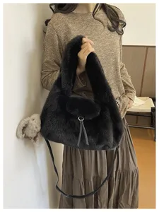 Model holding a black faux-fur handbag with a long leather shoulder strap and tassel detail