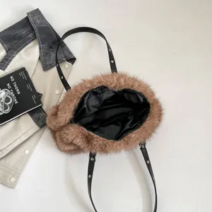 Draufsicht auf offene braune Kunstfelltasche mit schwarzem Satinfutter und Nieten an den Riemen