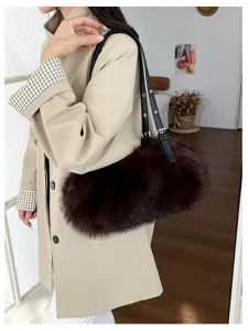 Dunkelbraune Plüschtasche mit langem schwarzem Riemen, über einem beigen Mantel getragen