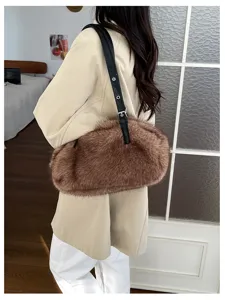 Rückansicht: braune Kunstpelztasche mit langem schwarzem Riemen über einem hellen Mantel