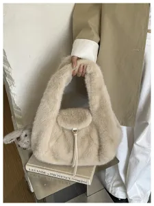 Close view of an ivory faux-fur bag with a soft rounded handle, flap and dangling tassel cord