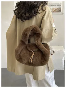 Back view of a model carrying a brown plush bag with a rounded silhouette and leather cord detail