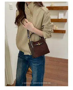 Lifestyle view of a model carrying a dark brown suede-look bag with leather trim and gold-tone clasp
