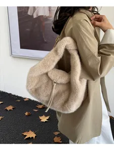 Close-up of a plush beige bag with a fur-covered handle and gold clasp, worn over the shoulder
