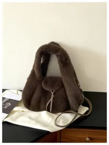 Brown plush bag with a rounded shape, leather drawstring closure, and long shoulder strap