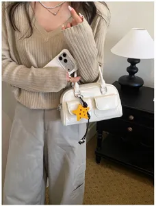 Borsa in PU color crema con tasche a patta e ciondolo a stella gialla, portata da una modella