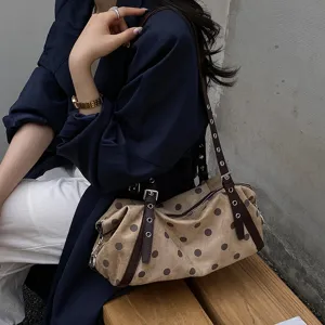 Retro taupe polka dot suede-look shoulder bag with brown straps and metal hardware, worn crossbody