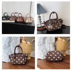 Borsa marrone a pois beige: manici in pelle, catenella decorativa e fondo arrotondato in dettaglio