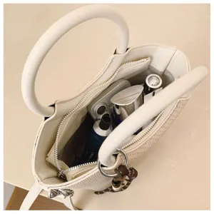 Vue plongeante sur l’intérieur ouvert du sac, sa poche zippée et les articles rangés à l’intérieur