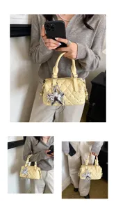 Modella con borsa trapuntata giallo chiaro, strass, ciondolo a stella e catena argentata