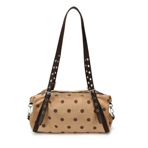 Tan faux-suede polka-dot shoulder bag with studded dark-brown straps, shown from the front