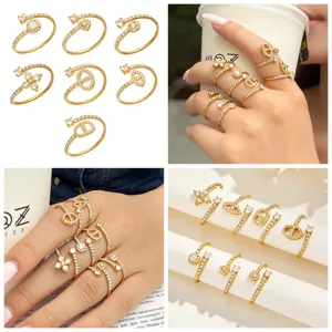Four-panel view of gold-tone open rings with clear stones, shown flat, worn on fingers and displayed