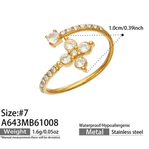 Close-up of a gold-tone open ring with clear stones, floral setting and a slim pavé band