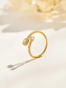 Close-up of a gold open ring with clear stones along the band and two larger stones at the top