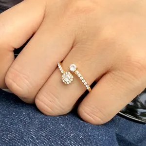 Gold-tone open ring with sparkling zircon stones, worn on a finger with two distinct jeweled ends
