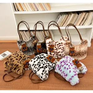 Sieben Plüschtaschen mit Tiermustern auf Holzboden, mit braunen Riemen und Bärenanhängern
