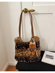 Detail einer braun melierten Kunstfelltasche mit Lederriemen und kleinem Teddybär-Anhänger