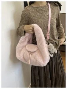 A model carries a fluffy pink bag with a front flap, tassel, gold hardware, and gray teddy charm