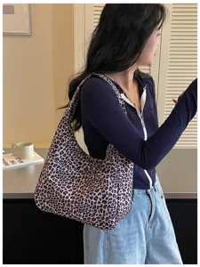 Donna con una grande borsa a spalla leopardata, mostrata in un look casual in un ambiente interno