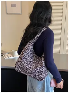 Una donna porta una capiente borsa con stampa leopardata in un ufficio dalla luce morbida