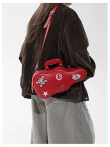 Modella con borsa rossa a tracolla a forma di chitarra, manico corto e decorazioni ricamate