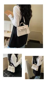 Una donna indossa una borsa bianca con patta e chiusura argentata in un ambiente interno luminoso.