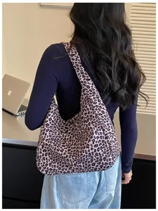 Vista posteriore di una modella con una morbida borsa rosa leopardata e un’ampia tracolla