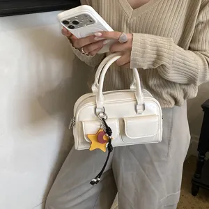 Borsa bowling bianca lucida, con doppi manici, tasche frontali con patta e ciondolo a stella, a mano