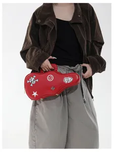 Borsa rossa a forma di chitarra, con decorazioni vivaci e zip metallica, in un look casual