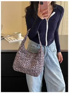Borsa morbida con stampa leopardata indossata a spalla, mostrata con un look casual in casa